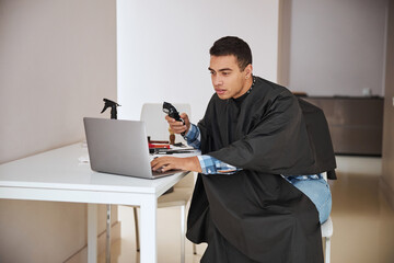 Concentrated man watching something on device at the table in home