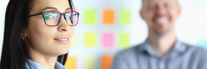 Fototapeta premium Business woman in glasses on background of smiling man. Lending and support to small and medium sized businesses concept
