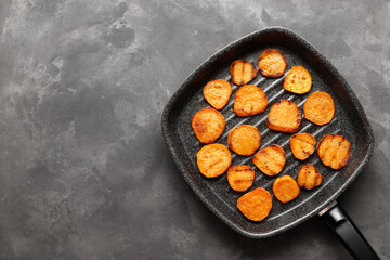 Grilled sweet potatoes with rosemary on the grill pan on the table close up. horizontal view from above