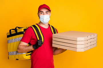 Portrait of healthy guy wear gauze mask carrying bringing pizza boxes stop mers cov pandemia social distance isolated on vivid yellow color background