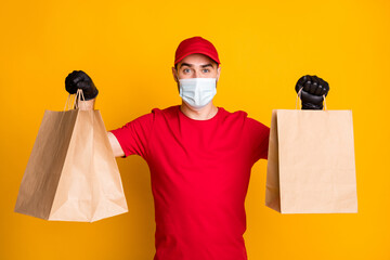 Portrait of healthy guy wear gauze mask carrying bringing cafe order takeaway takeout isolated on vivid yellow color background