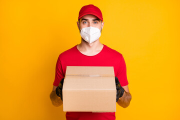 Fototapeta na wymiar Portrait of healthy guy wear n95 respirator bringing parcel shop store order stop pandemia concept isolated on vivid yellow color background