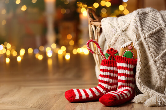 Socks filled with sweets on floor in room, space for text. Saint Nicholas Day