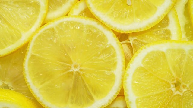 Zoom on juicy yellow lemon cut into round slices.