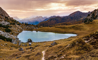 Overcast morning autumn alpine Dolomites mountain scene. Peaceful Valparola Path and Lake view, Belluno, Italy.