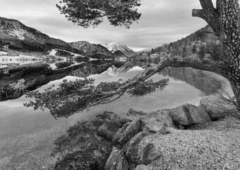 Grayscale. Cloudy winter Alpine  lake Grundlsee view (Austria) with fantastic pattern-reflection on...