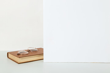An old book and glasses on the table, on a white background, the concept of reading and learning. Copy space.