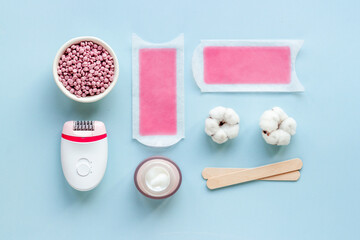 Cosmetics set for epilation with epilator and wax strips and flowers. Top view