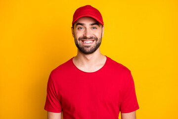 Photo portrait of delivery worker wearing red uniform cap smiling isolated on bright yellow color background