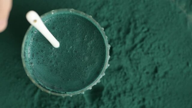 glass of milk with spirulina powder view from top