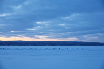 Fototapeta na wymiar Evening view of the frozen lake. Sky with dramatic clouds