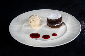 Dessert of ice cream and cupcake on a white plate on a black background