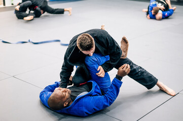 Two Jiu-Jitsu practitioners fighting on the mat in training