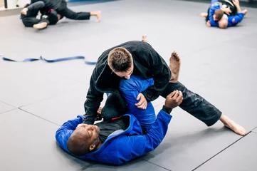 Fotobehang Two Jiu-Jitsu practitioners fighting on the mat in training © OscarStock