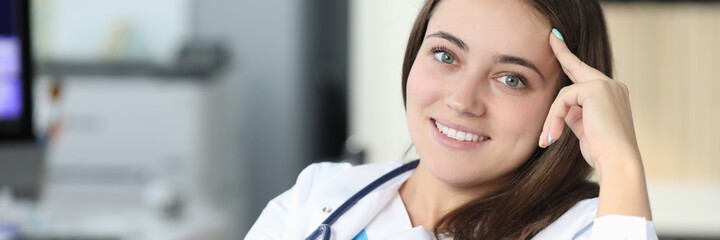Young beautiful woman doctor with phonendoscope around her neck smiling during break from work portrait. Recreation of medical personnel while working in clinic concept.