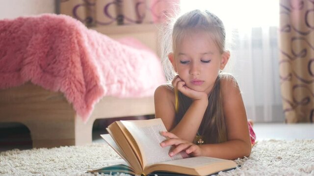 Portrait sad schoolgirl does not want to study and read a book. A sweet blonde girl is sleeping on a book, she is tired when she did her homework.