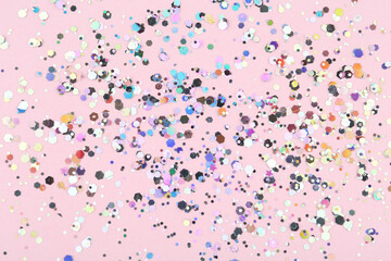 Shiny glitter on light pink background, top view