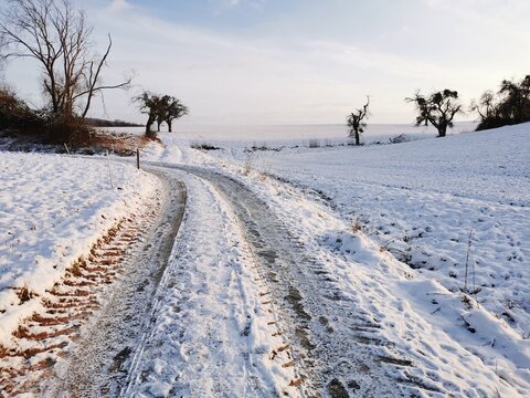 Ein Feldweg durch verschneite Äcker