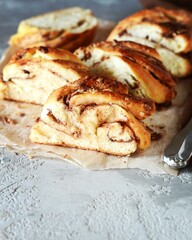 Cinnamon twisted loaf bread or babka on a dark wooden background, still life, rustic style