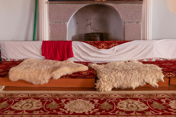 Oriental room decorated with carpet rugs and sheepskin. The seat of alevi grandfather in cem house.