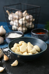 Bowl of fresh garlic on table