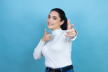 Young caucasian woman wearing white sweater over blue background