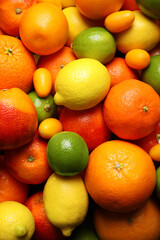 Different ripe citrus fruits as background, closeup