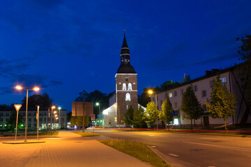 Fototapeta na wymiar Night view of an architectural street with a historic old church and car lights long exposure