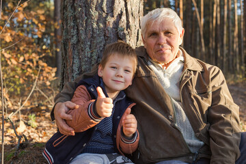 Happy child with Grandfather playing at the forest. Grandpa retiree. Retirement parent. Portrait of...