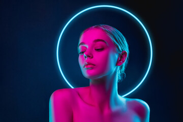 Future. Portrait of female fashion model in neon light with neoned blue glowing circle on dark studio background. Beautiful woman with trendy make-up and well-kept skin. Vivid style, beauty concept. - obrazy, fototapety, plakaty