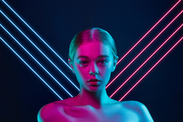 Future. Portrait of female fashion model in neon light with neoned blue glowing lines on dark studio background. Beautiful woman with trendy make-up and well-kept skin. Vivid style, beauty concept. - obrazy, fototapety, plakaty
