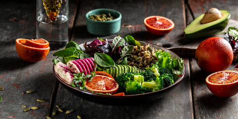 Healthy vegetarian buddha bowl salad with vegetables and fruit avocado, blood orange, broccoli, watermelon radish, spinach, quinoa, pumpkin seeds, Vegan, detox green Buddha bowl recipe