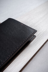 Leather passport cover lies on a geometric background consisting of brown and gray triangles with a light rectangle close up