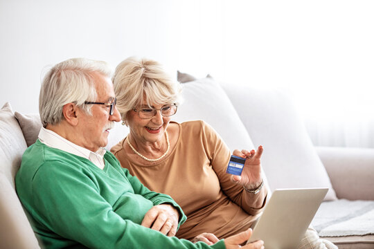 Senior couple happy laptop online shopping debit credit card order ecommerce. Portrait of happy smiling senior couple using laptop and credit card at home.