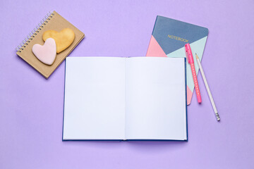 Blank open book, cookies and notebook on color background