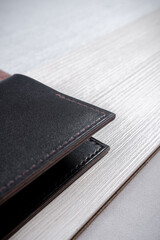 Leather passport cover lies on a geometric background consisting of brown and gray triangles with a light rectangle
