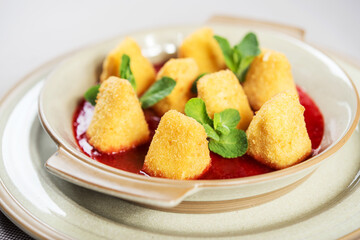 portion of fresh made fried camembert cheese served with berry jam