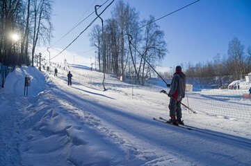Skiers on a ski lift on a small ski slope on the outskirts of Moscow.