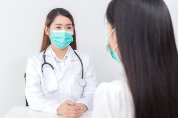 Asian woman doctor is talking with her patient to consult and check symptom which wears medical face mask always diagnostic in new normal and health care concept.