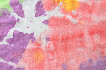 Pastel tie dye, a handmade pattern on a cotton t-shirt. Close-up, top view. DIY concept, handicrafts, original everyday clothes, fabric dyeing techniques. Flat lay, horizontal. Abstract background