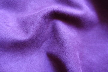 Fototapeta na wymiar Close view of draped violet faux suede fabric