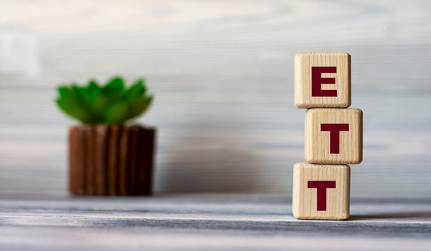 ETT - acronym on wooden cubes against the background of a light board with beautiful divorces and a cactus