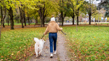 Woman with her dog in a park, autumn