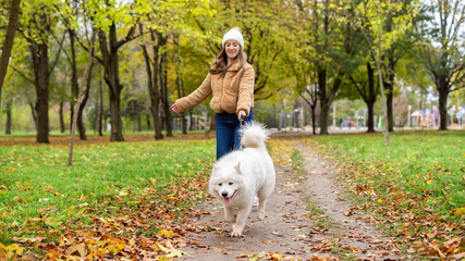 Woman with her dog in a park, autumn