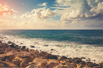 Rocky seashore on a sunny day. Nature landscape, sea with beautiful cloudy sky