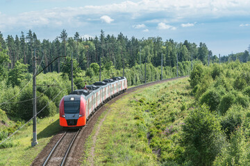 Fototapeta premium Passenger train approaches to the station at summer day.
