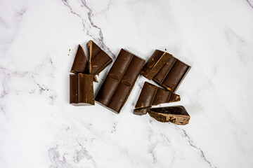 quality chocolate on white marble bottom tablet into pieces
