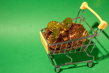 shopping cart filled with gold coins set against a blue background