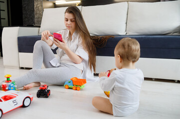 Young woman ignore her kid and looking at their mobile phones