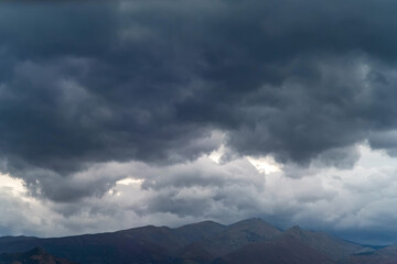 Gray sky with storm clouds over the mountains